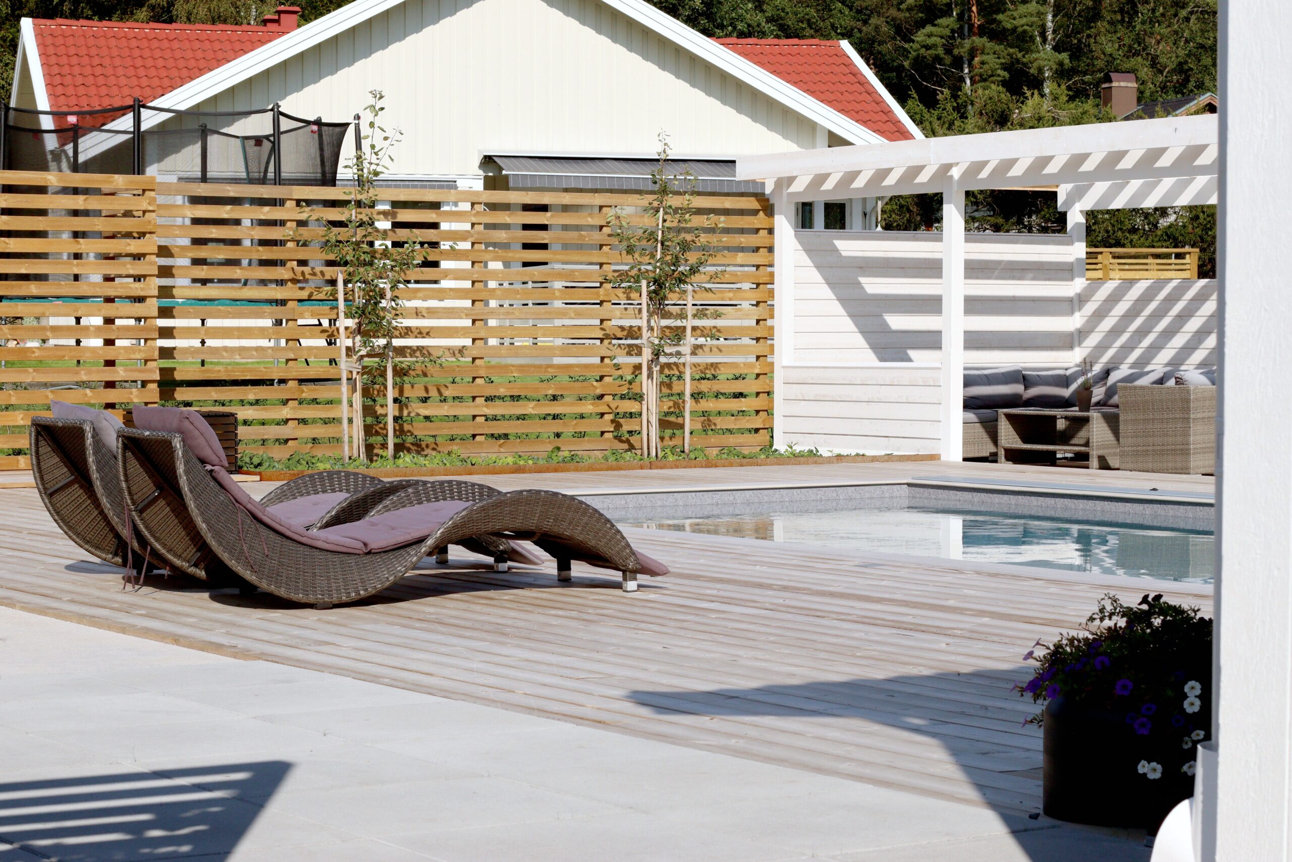 Poolträdgård i lantlig miljö pool solstolar pergola - Natalia lindberg trädgårdsdesign