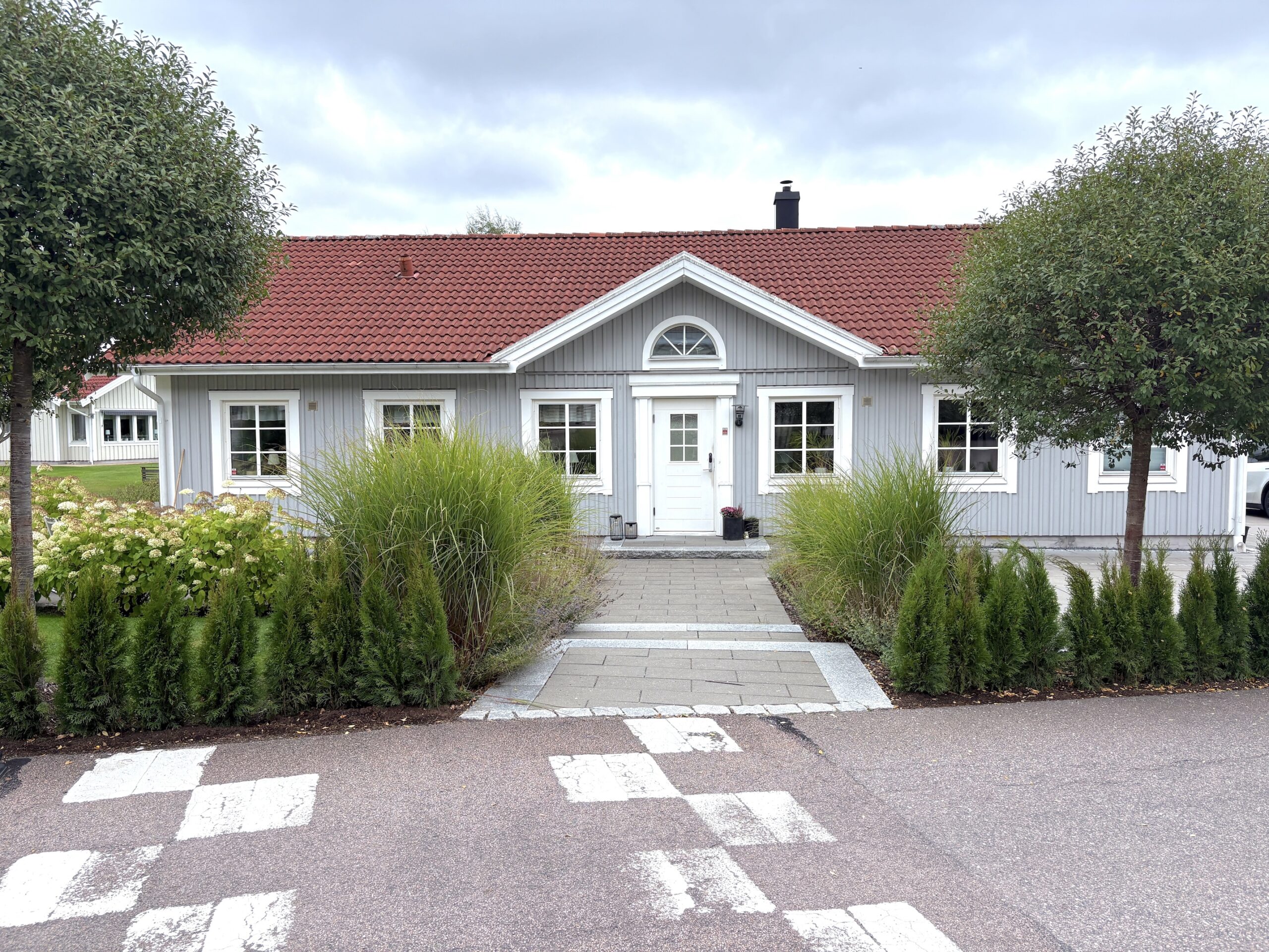 Anlagt poolområde vid modernt svart hus i Askim.