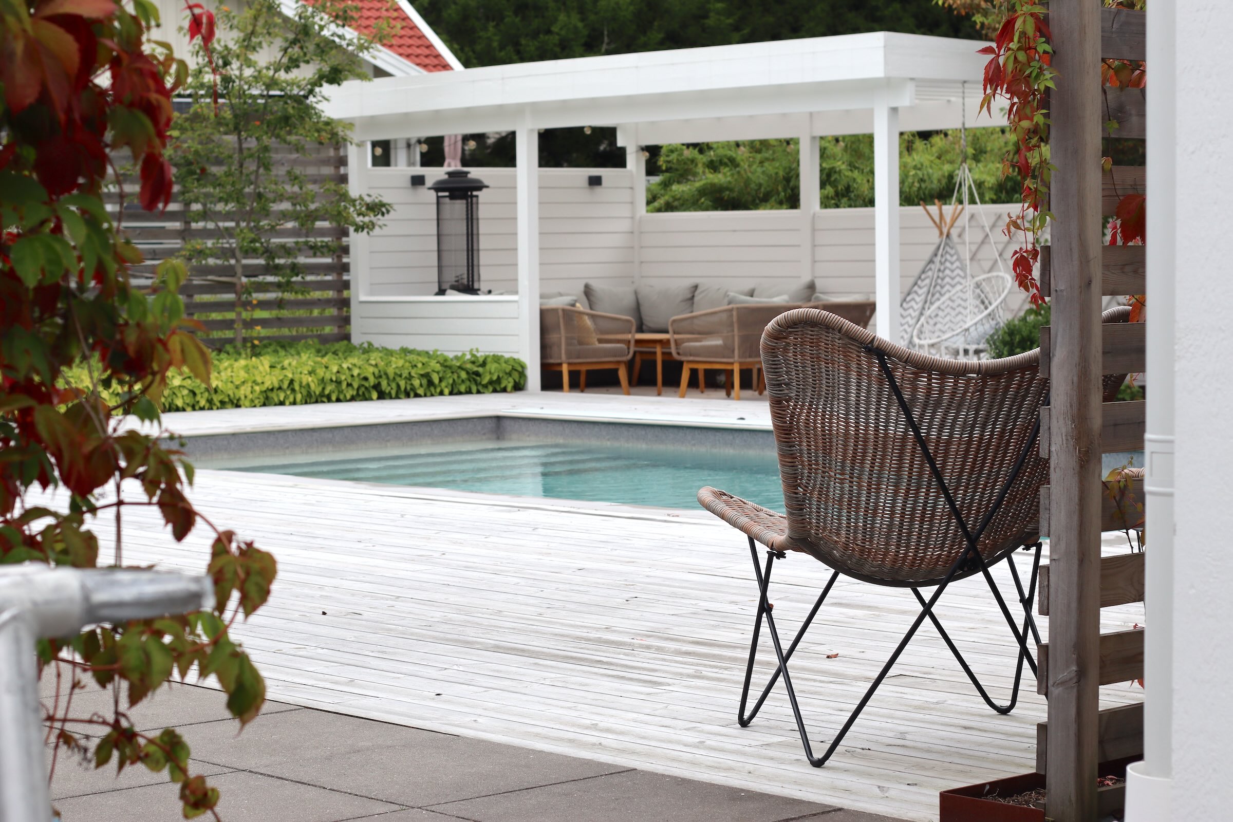 Anlagd lantlig trädgård med pool, pergola och uteplatser i Kungälv